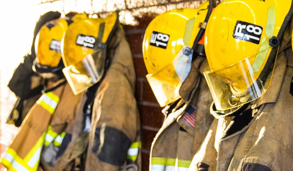 firefighter gear hanging on a coat rack